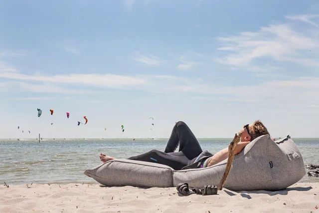 Twee mensen liggen op een BRYCK ligelement op het strand